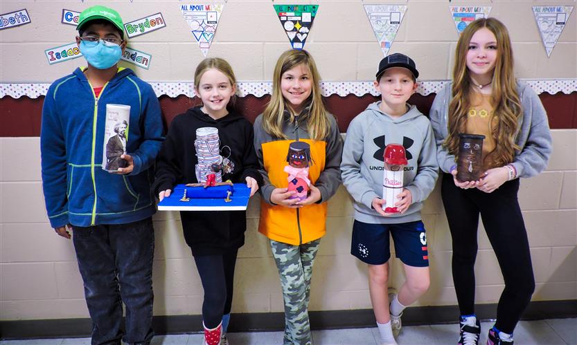 Students hold up Characters in a Can